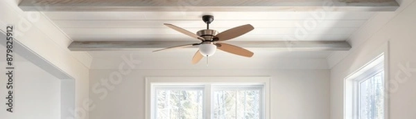 Obraz Modern ceiling fan with wooden blades in a bright, minimalist room with white walls and large windows for natural light.