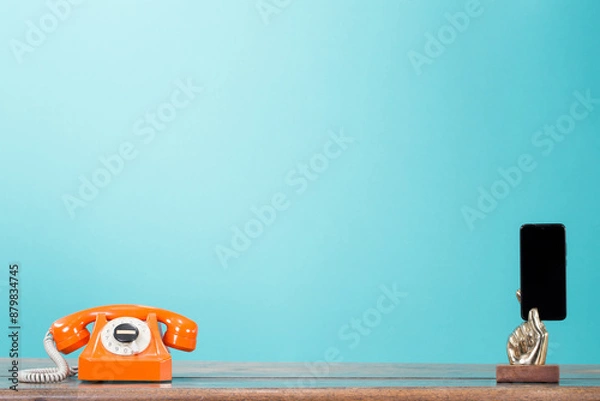 Obraz Retro telephone and mobile phone in golden arm front gradient mint blue background. Vintage old style filtered photo. Contact numbers  banner concept
