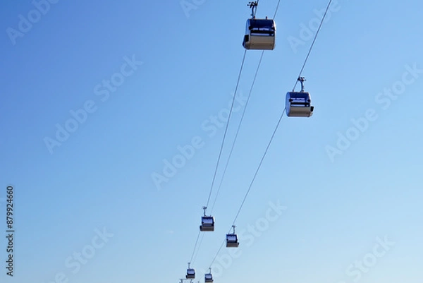 Fototapeta Cabins ride on a cable car against the sky. View from below. Funicular