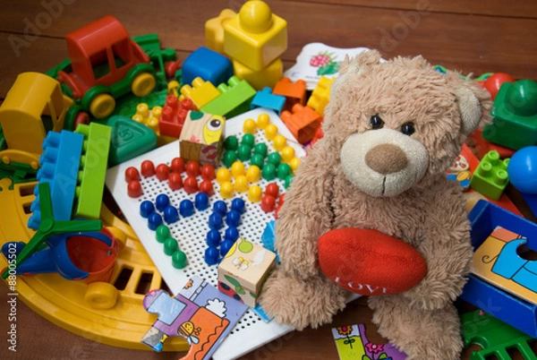 Obraz teddy bear surrounded by plastic toys
