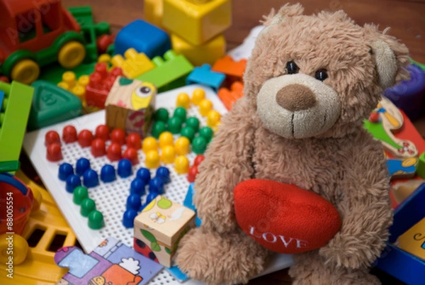 Obraz teddy bear surrounded by plastic toys