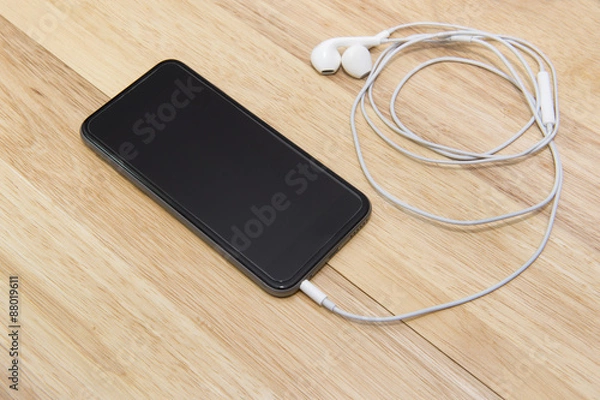 Fototapeta smart phone and note on wooden background