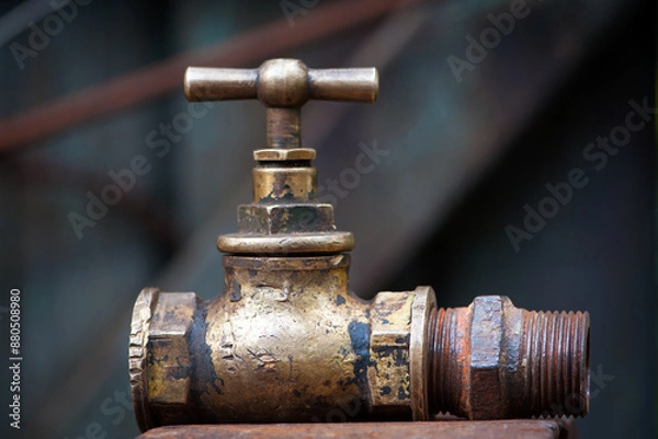 Obraz Vintage old brass water tap isolated on a dark background. tap valve. old copper retro faucet on a rusty pipe. plumbing, repair, dismantling. close-up