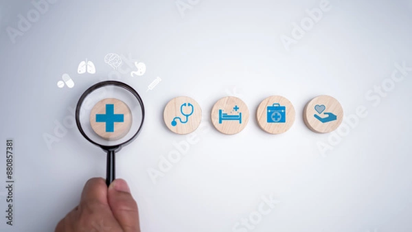 Fototapeta Human hands hold a magnifying glass and focus on the plus sign and healthcare medical icon on white background, Health insurance concept, Health and access to welfare health concept.
