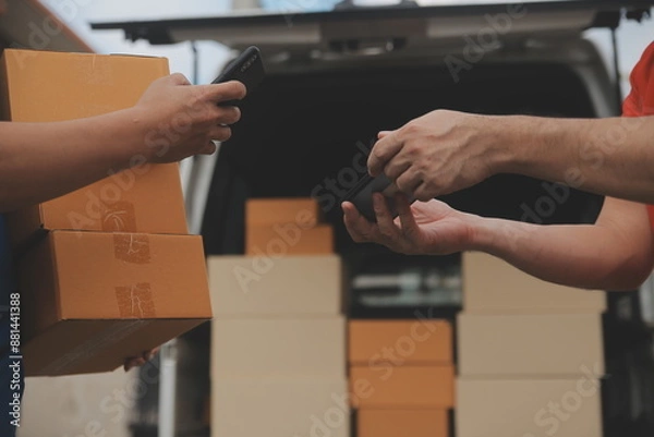 Fototapeta Asian delivery express courier young man use giving boxes to woman customer he wearing protective face mask at front home