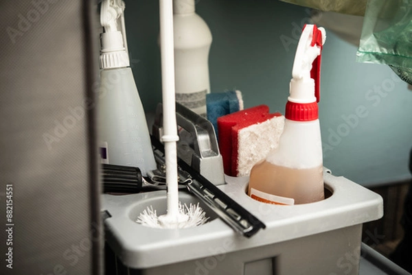 Fototapeta A storage caddy is filled with essential cleaning supplies including sprays, scrubbers, and tools, providing efficient organization for cleaning tasks at home or in commercial settings. 