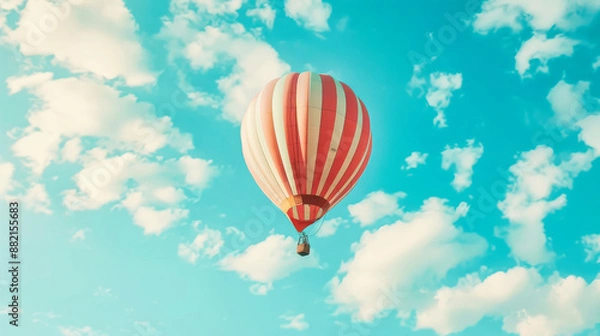 Fototapeta A hot air balloon floating in the sky with white clouds