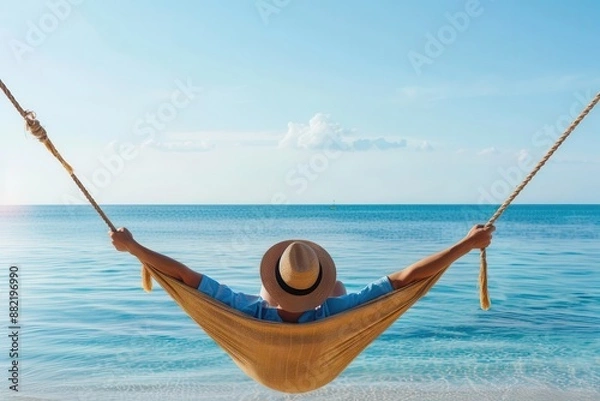 Fototapeta A person lounging in a hammock by the beach, representing ultimate relaxation