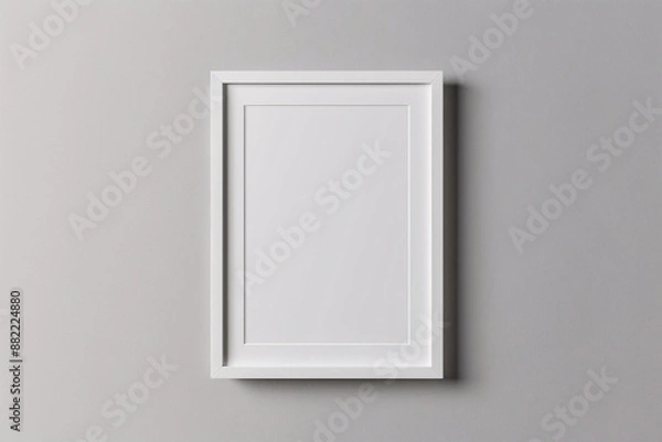 Fototapeta  A photo mockup featuring a blank white frame centered on a plain, light gray background. The frame ratio is perfectly balanced, with sharp edges and clean lines, providing an ideal template for