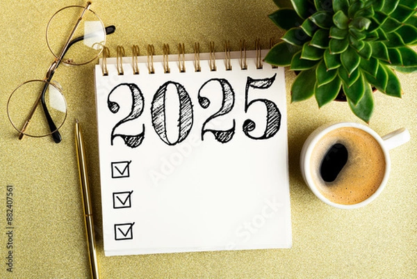 Fototapeta 2025 New year resolutions on desk. 2025 goals list with notebook, coffee cup, plant on golden background. Resolutions, plan, goals, action, checklist, idea concept. New Year 2025 resolutions