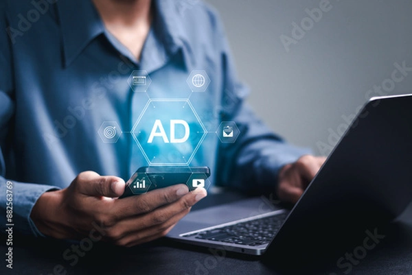 Fototapeta Online advertisement concept. Businessman using smartphone with advertising icon on virtual screen. AD on website or social media, online ads and digital marketing.
