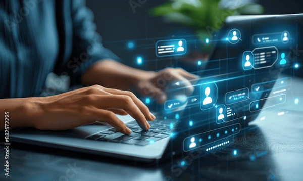 Fototapeta Business Woman Using Laptop with Virtual Display Showing Chat App Icons and Transferring Information to Mobile Phone for Online Work with Chatbot Assistance and CRM Technology