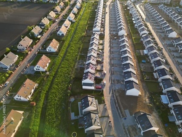 Fototapeta Rows of identical new, single-family houses in a suburban estate, real estate market, modern suburban housing track, aerial view.