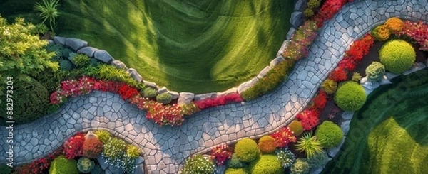 Fototapeta Top view of beautiful ornamental stone wall with flower beds and grass in the middle, on top is an aerial photo of large green lawn and colorful flowers.
