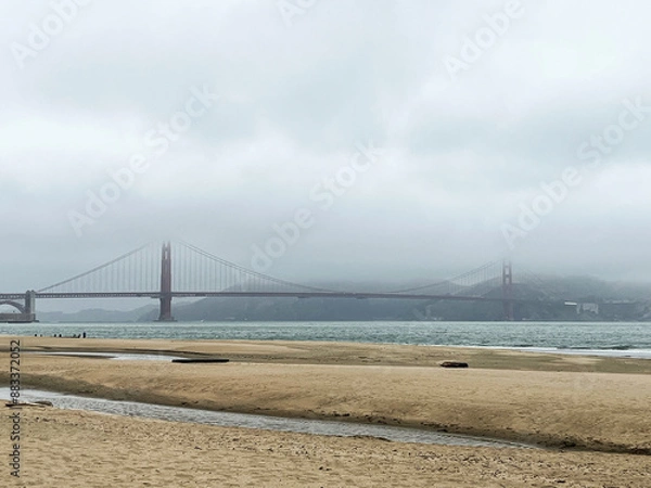 Fototapeta Coastal view of the Golden Gate bridge in San Francisco. American iconic landmark. Cliffs and grass frame the picture. Waves in the bay water. Light fog.
