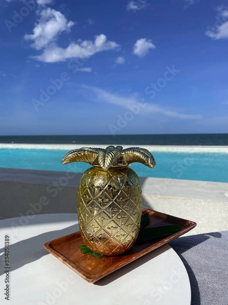 Fototapeta Pineapple juice, a refreshing drink with a sea view.