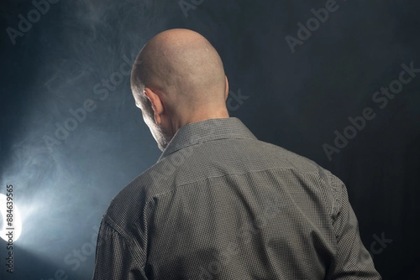 Fototapeta Bald middle-aged man with his back to the camera.
