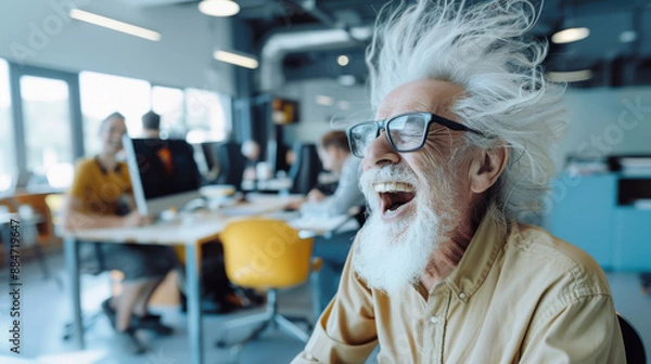Obraz A colorful and expressive image of an elderly man with wild white hair and glasses, laughing out loud, in a modern office space with colleagues working at desks and computers