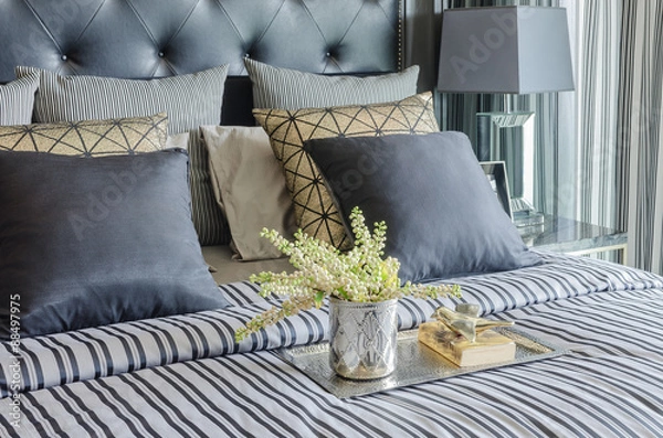 Fototapeta tray of book with vase of  plant on bed in luxury black bedroom