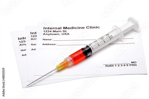 Fototapeta A medical prescription pad and a hypodermic syringe.