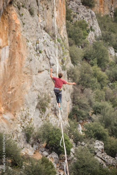 Obraz A man walks on a tightrope over an abyss.