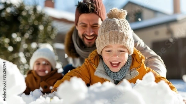 Fototapeta A child joyfully playing in the snow with family, fully embracing the winter fun, showcasing the warmth and togetherness felt during snowy outdoor activities.