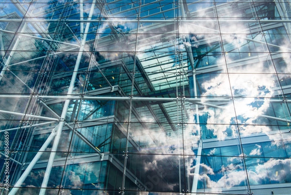 Fototapeta Sky and clouds reflected in the windows of an ecological and sustainable building.