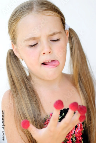 Obraz a mischievous, cheerful little girl with freckles rejoices and makes faces