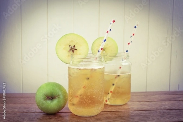 Fototapeta Cider apple juice in glass jars on a wooden surface