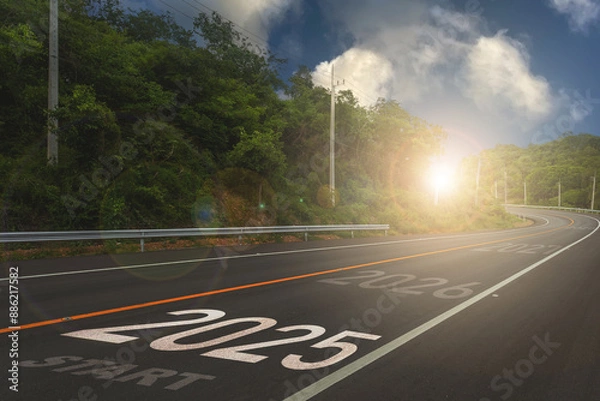 Fototapeta 2025,The New Year 2025 or the beginning of the concept of the word 2025 is written on the road in the middle of the asphalt road with a sunset mountain backdrop, concepts.