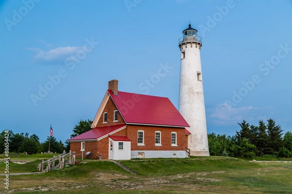 Obraz Tawas point lighthouse in the evening against blue sky