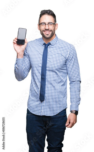 Fototapeta Young business man showing smartphone screen over isolated background with a happy face standing and smiling with a confident smile showing teeth