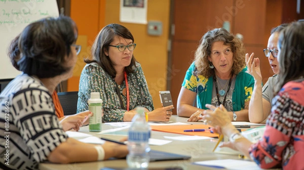 Fototapeta Group of teachers sitting around a conference table, brainstorming ideas for curriculum development 