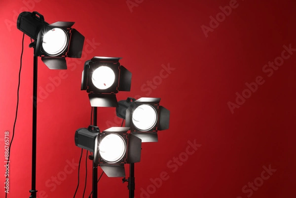 Fototapeta Red photo background and professional lighting equipment in studio, space for text
