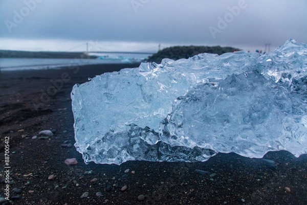 Fototapeta stranded icebergs on a dark pebbly beach in jökulsárlón in iceland