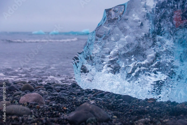 Fototapeta stranded icebergs on a dark pebbly beach in jökulsárlón in iceland
