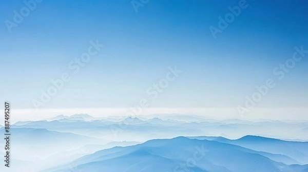 Obraz   A view of a mountain range in the distance with a clear blue sky in the foreground and a hazy sky in the background