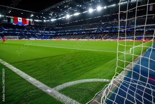 Obraz Aerial view of a modern football stadium at night, illuminated against the backdrop of a city skyline.