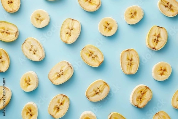 Fototapeta Banana Slices Pattern on Light Blue Background 