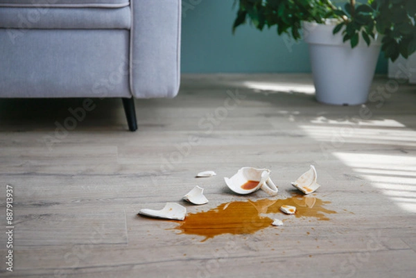 Obraz A broken cup of coffee fell on laminate, coffee spilled on floor.