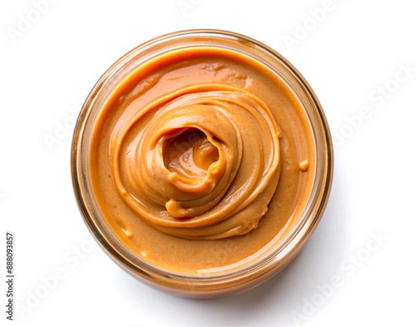 Fototapeta Peanut paste in a jar top view, the texture of the cream is brown