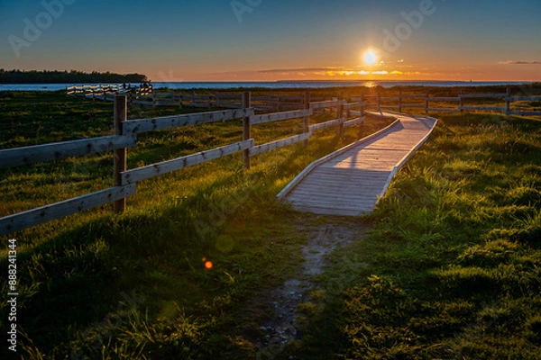 Obraz Boardwalk through flood meadows to the seashore. Sunset on the Baltic Sea. Hiking trail in Paljassaare, Tallinn,  Estonia.