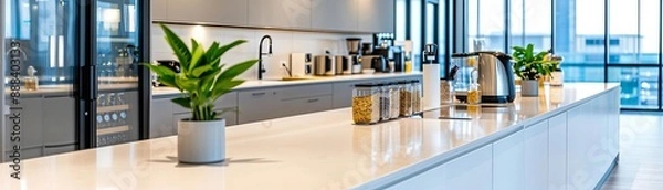 Obraz Modern office kitchen with white counters, potted plants, and sleek appliances in a bright, open-plan space.
