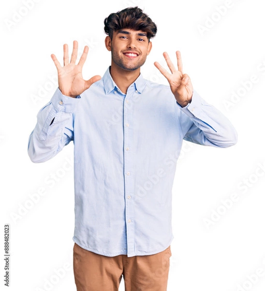 Fototapeta Young hispanic man wearing casual shirt showing and pointing up with fingers number eight while smiling confident and happy.