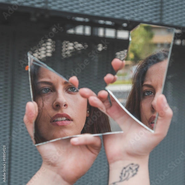Obraz Beautiful girl looking at herself in a broken mirror