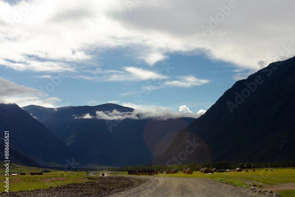 Obraz Small Altay village in valley between mountains. Beautiful landscape with green hills, blue sky and houses on sunny day