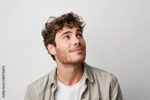 Fototapeta Portrait of a happy European man dressed casually looking satisfied and smiling noticing something in the distance