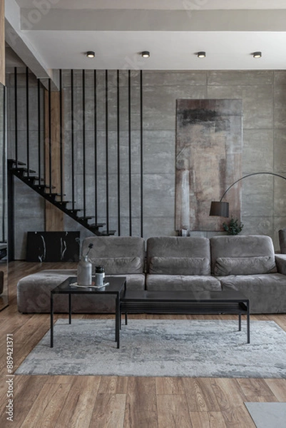 Obraz stylish minimalistic restrained modern interior of a two-storey apartment without people in the daytime in loft style in gray tones.