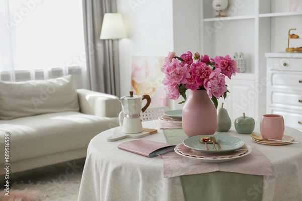 Fototapeta Beautiful table setting with pink peonies in living room. Space for text