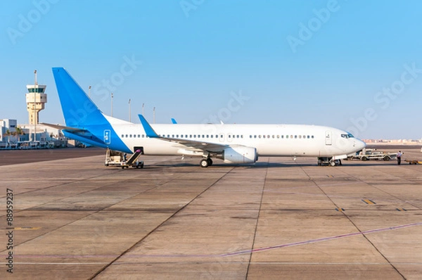 Fototapeta The plane at airport with control tower on loading